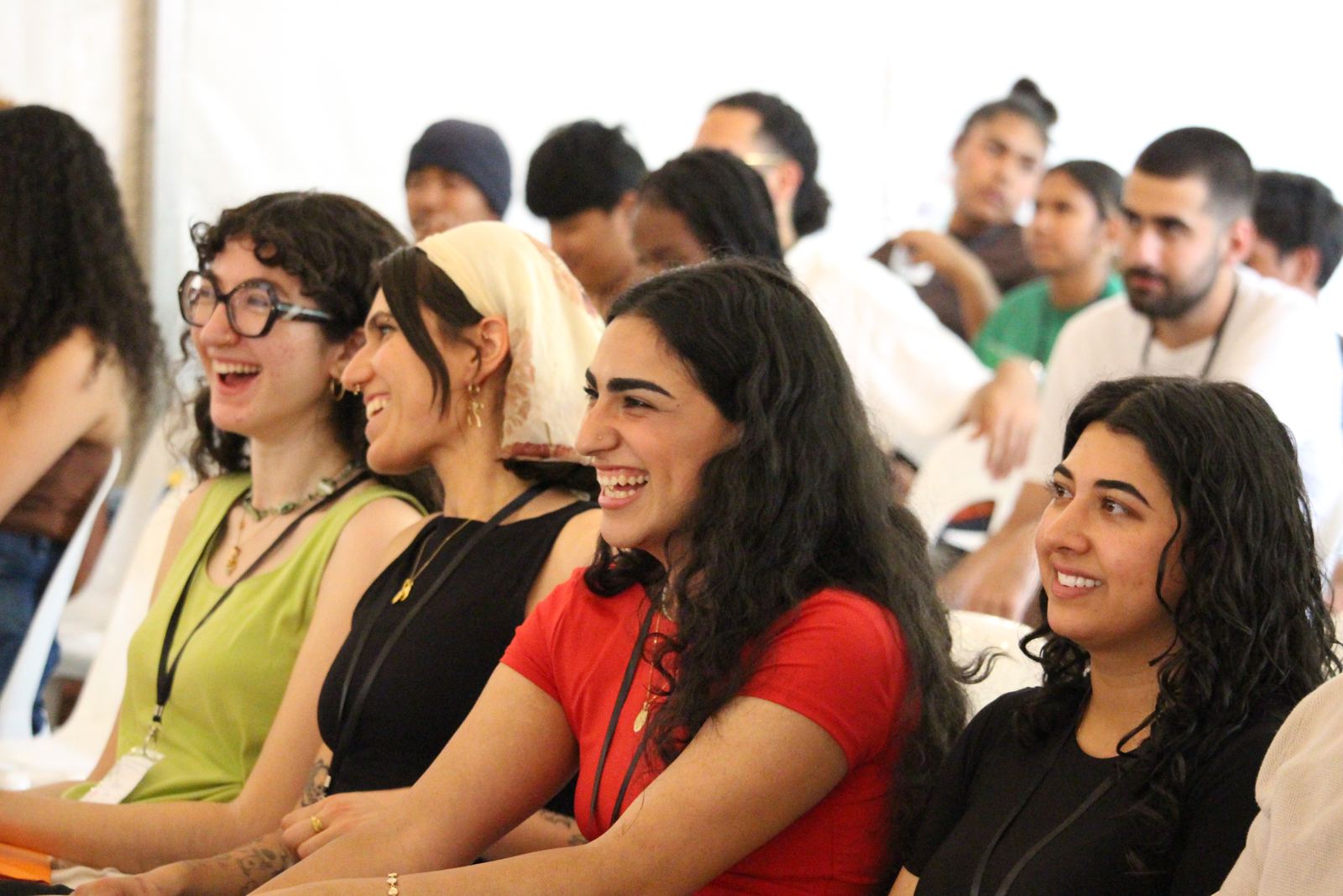 A row of young women laughing in the audience